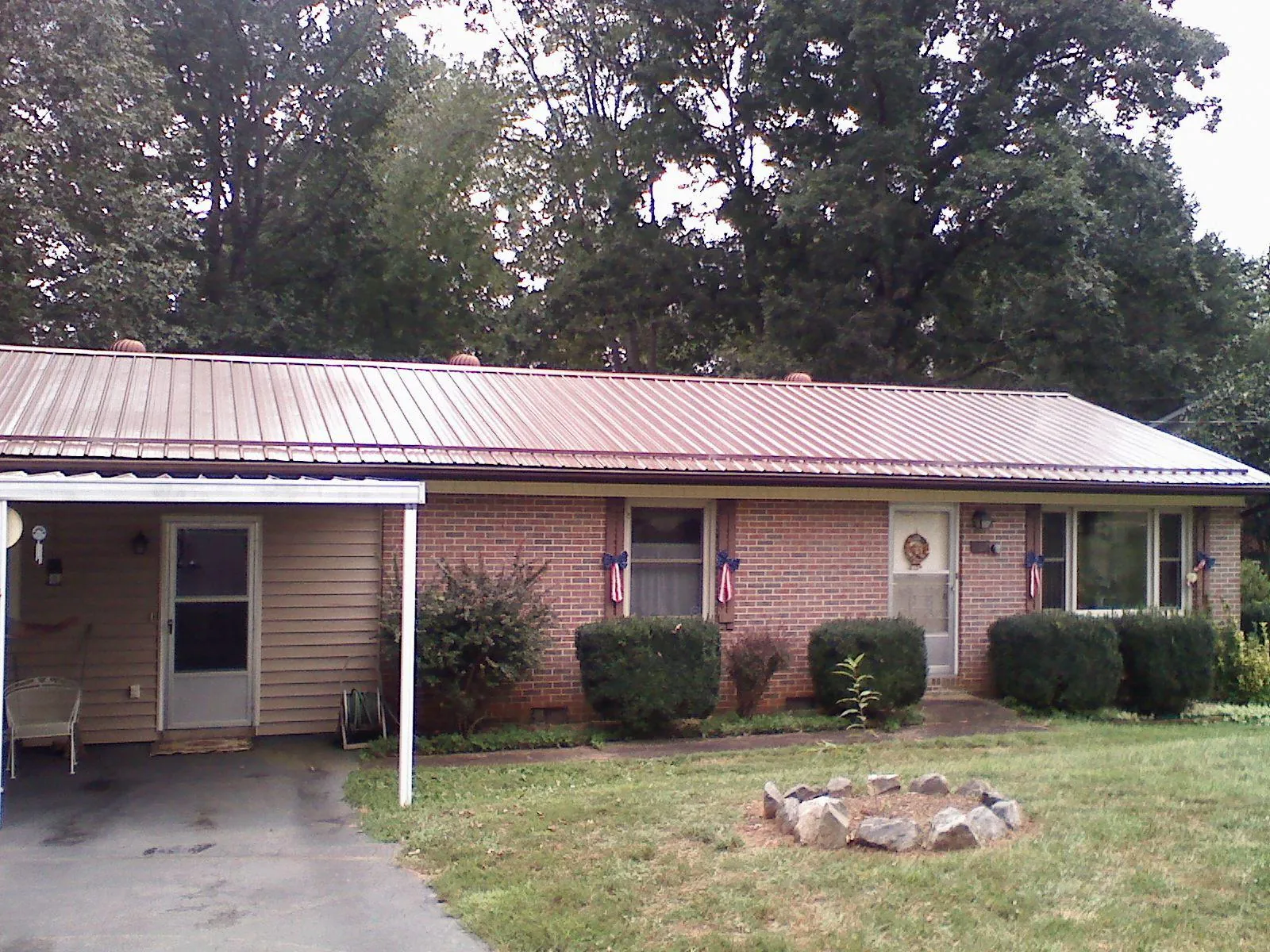 Bronze metal roof and carport on a brick ranch home — Roof Repair work by our crew in Allyn