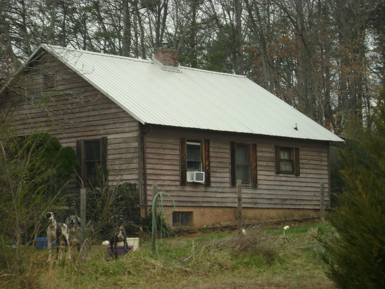 White metal roof on an old wood sided farmhouse, from a Metal Roof Installation job in Allyn